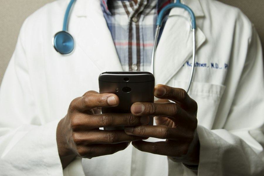 Médico con teléfono celular y estetoscopio